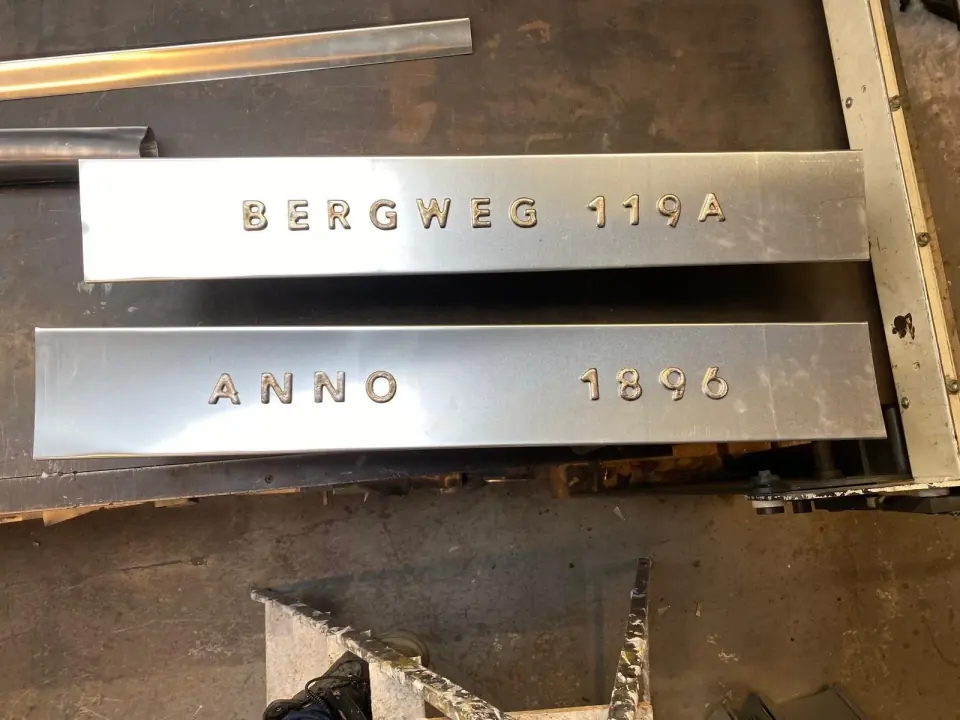 Metalen huisnummer- en jaartalletters op de werkbank