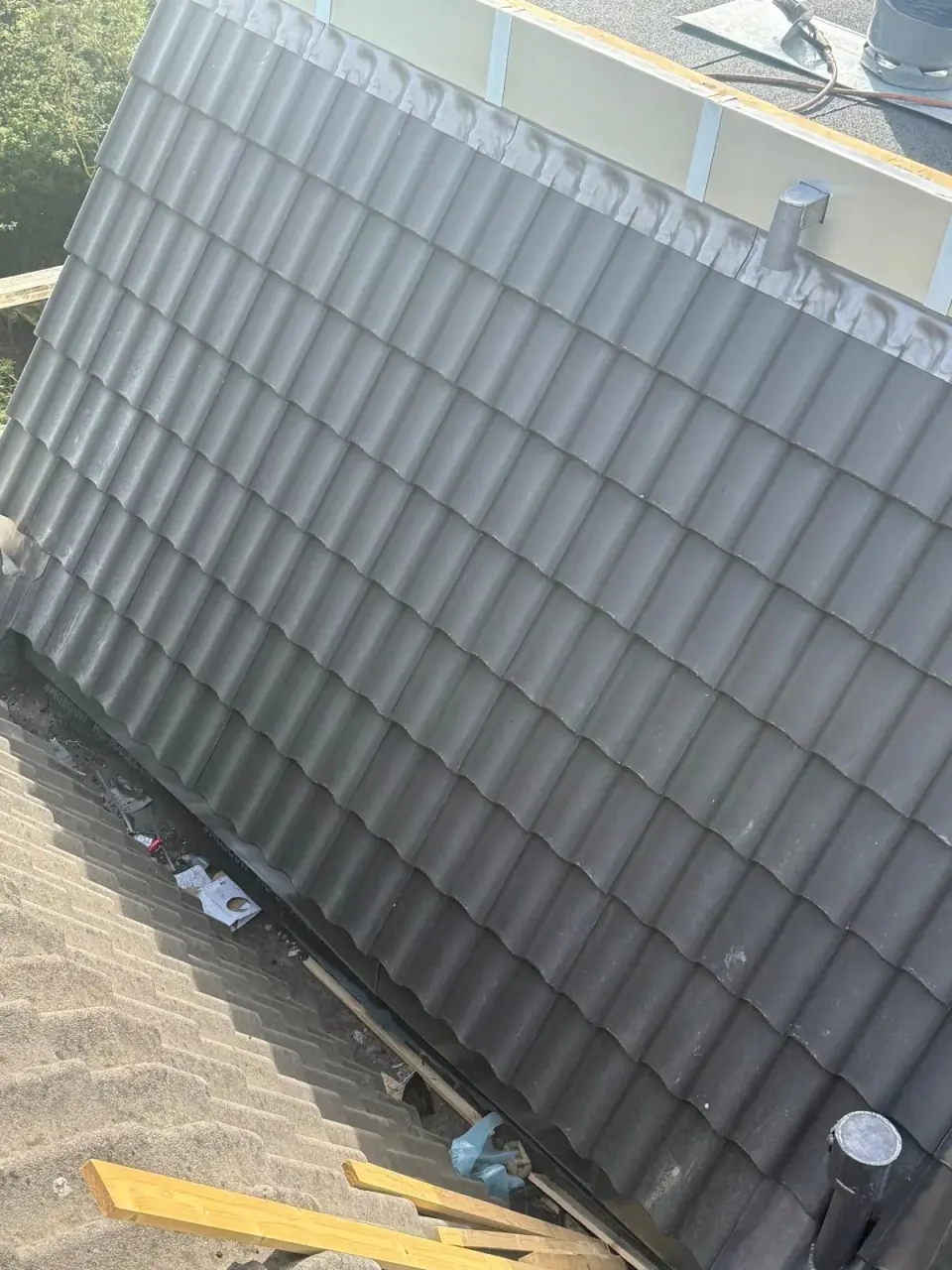 Dakdoorvoeren tussen grijze dakpannen