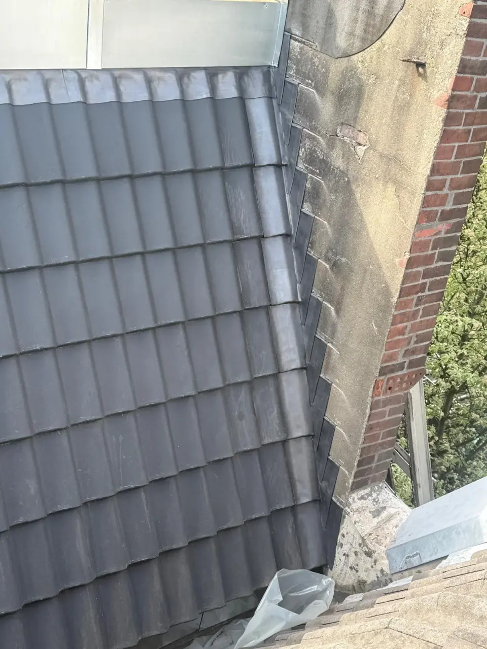 Wandaansluiting naast een grijs pannendak