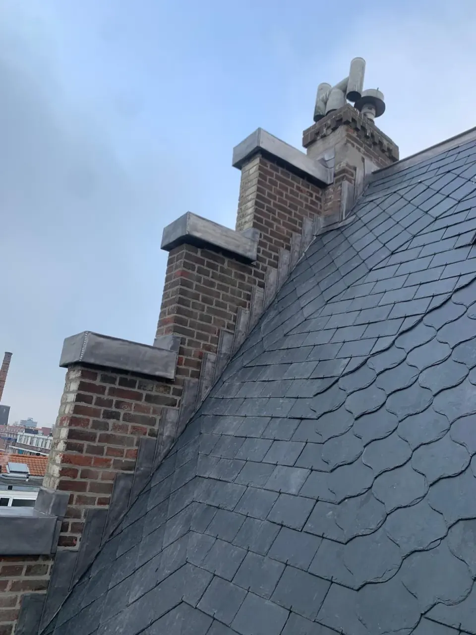 Steil leien dak langs een gemetselde trapgevel