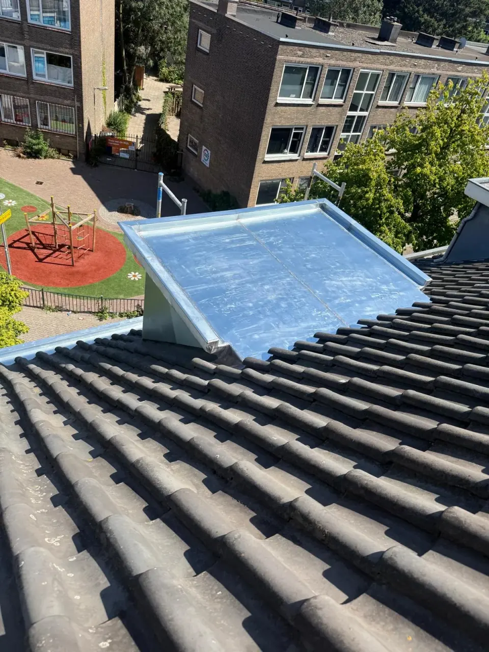 Metalen dakkapeldak en aangrenzende dakpannen