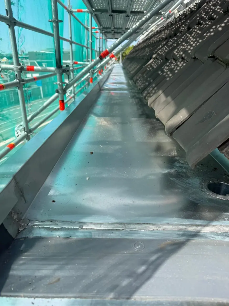 Lange metalen goot langs de steiger