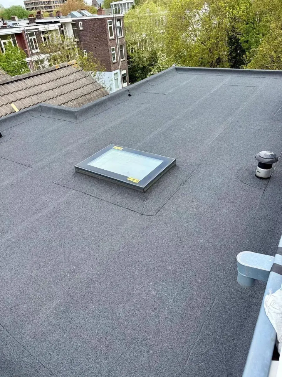 Lichtkoepel op een bitumen dakvlak