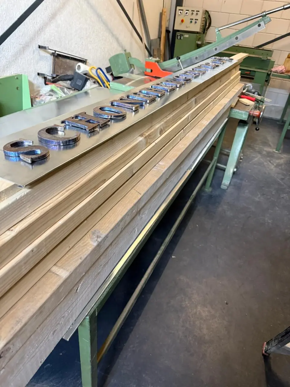 Uitgesneden metalen letters op de werkbank